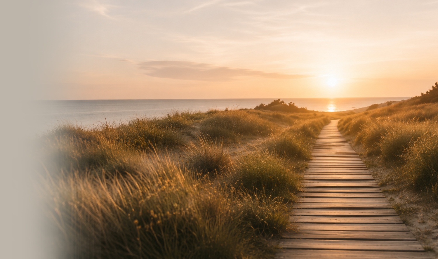 Un camino entre dunas que conduce hacia el horizonte al atardecer